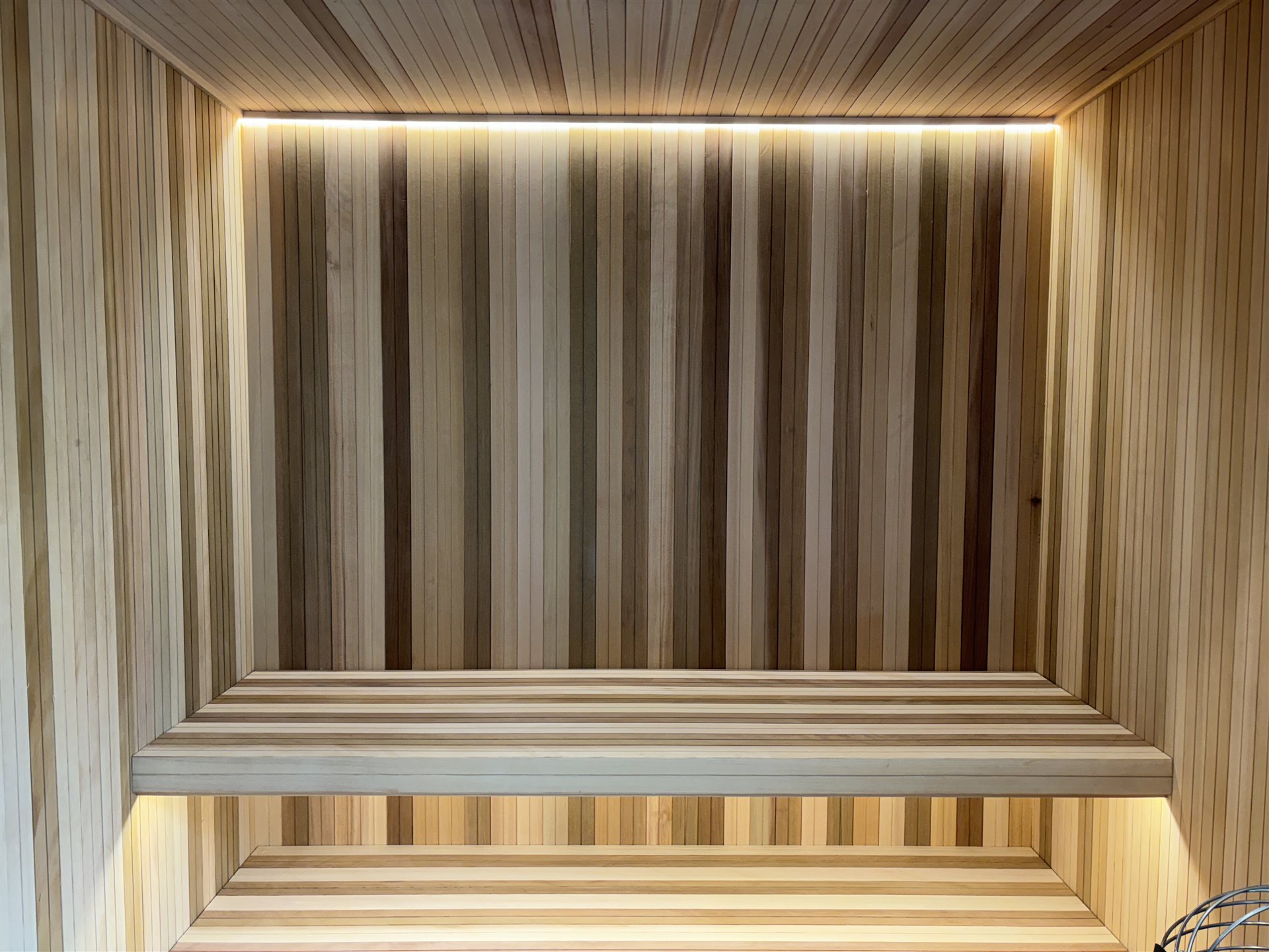 Clear cedar sauna interior with two-tier benches — The Wellness Suite