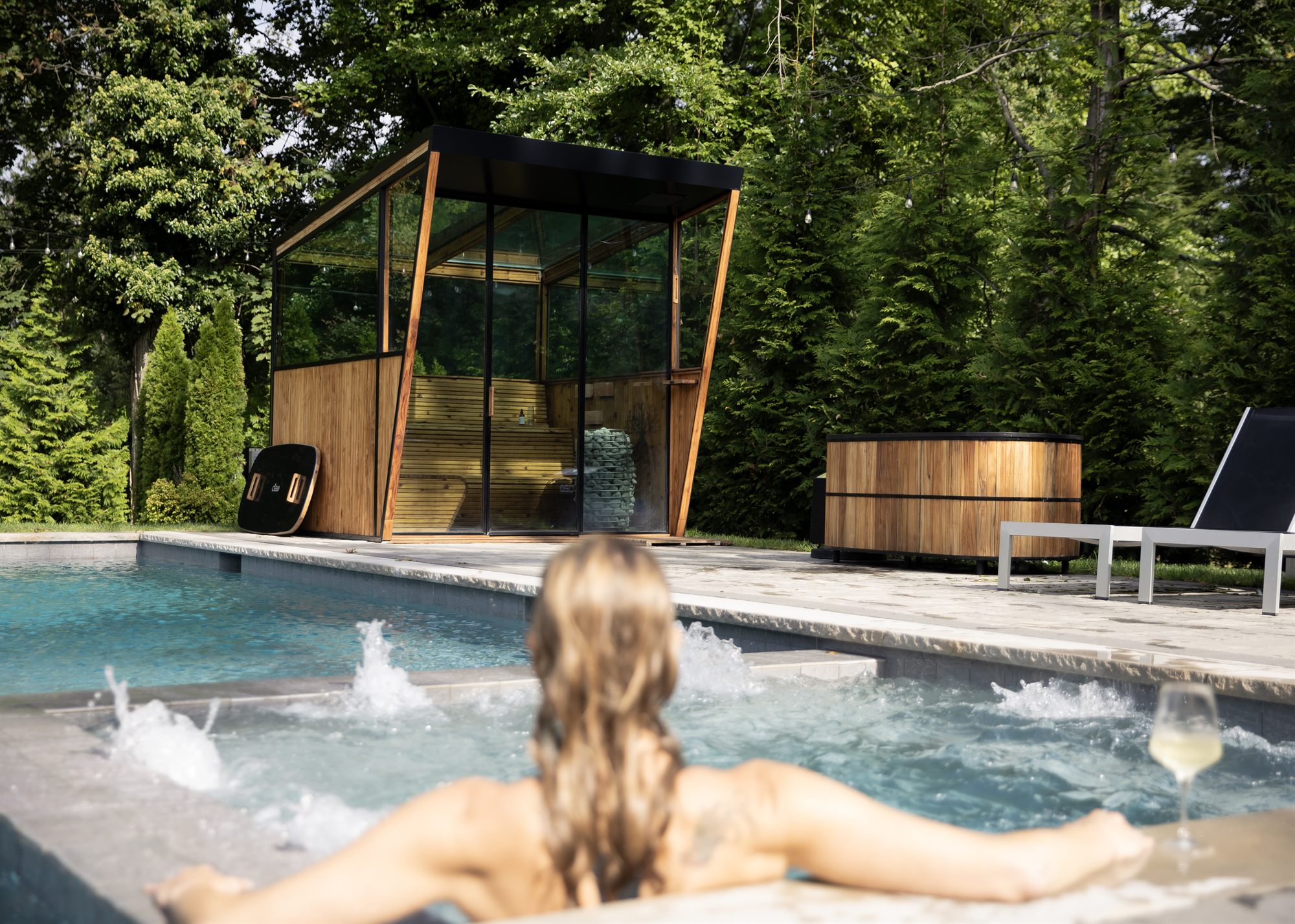 A Cielo glass roof sauna at dusk, sky visible through the glass