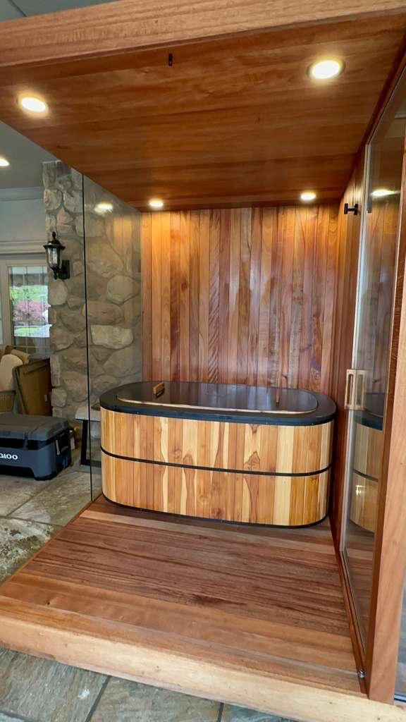 Cedar-wrapped cold plunge bay built into a glass-walled sauna structure