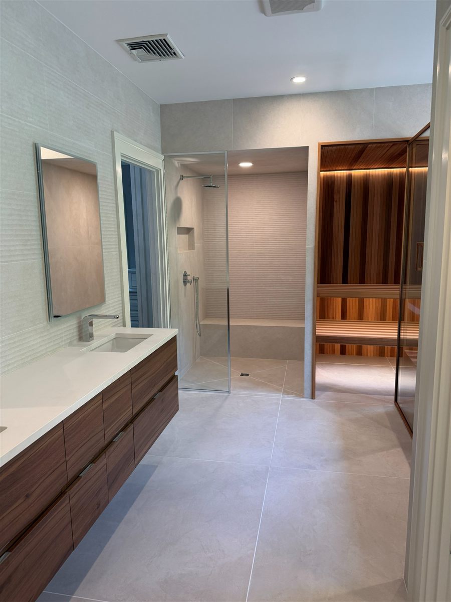 Indoor integration: cold plunge built into an existing bath suite alongside a sauna