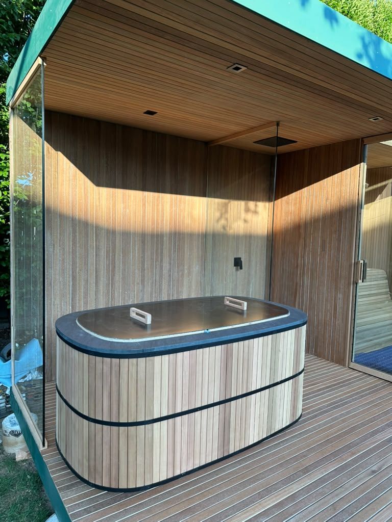 An outdoor cold plunge and cedar sauna structure built for daily use