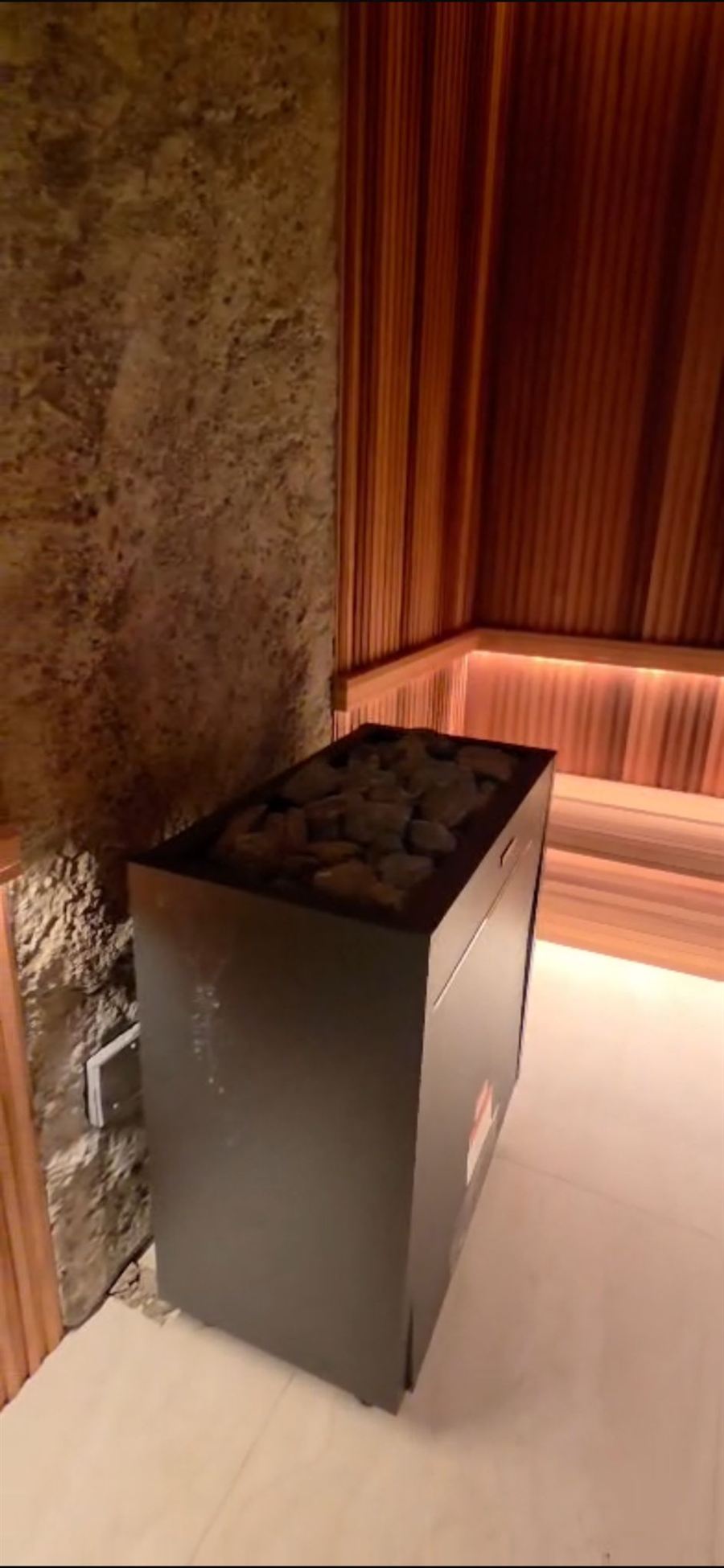 Sauna heater detail in a commercial wellness suite